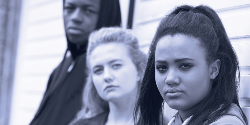 Three youth looking at camera, not smiling.