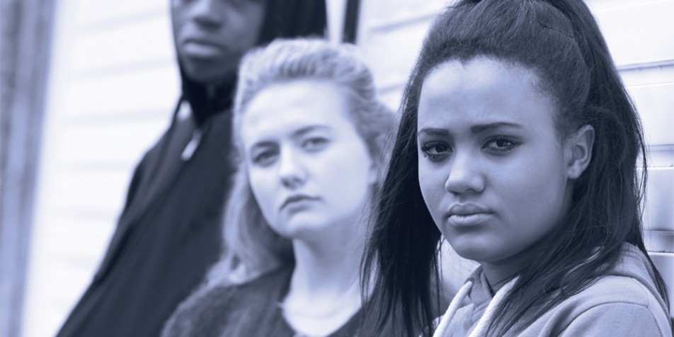 Three youth standing together, looking at the camera.