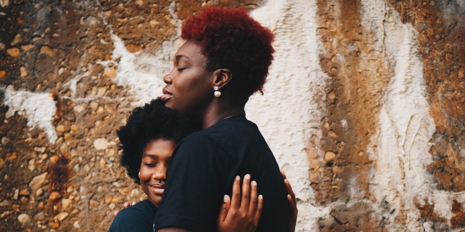 Woman hugging adolescent child.