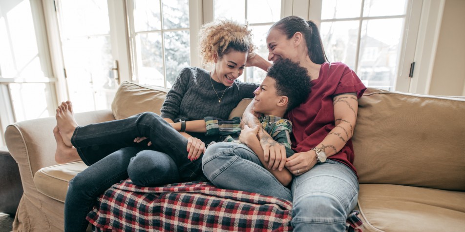 Family sitting on the couch together.