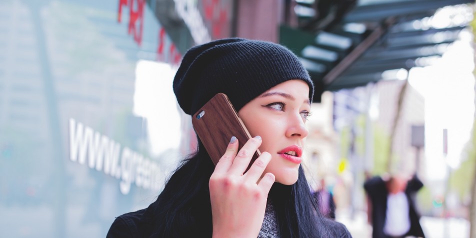 White woman holding a cell phone to her ear, looking off camera.