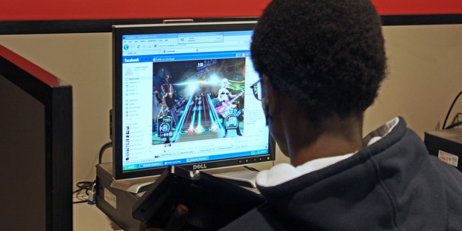 A young man reading at a computer.