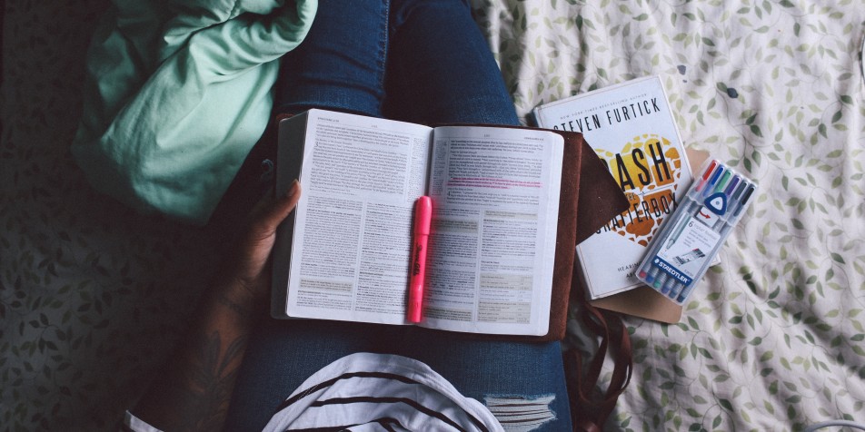 books and hand on someone's lap. 