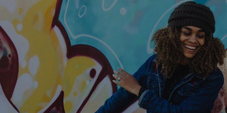 image of young woman dancing in front of graffiti wall. 