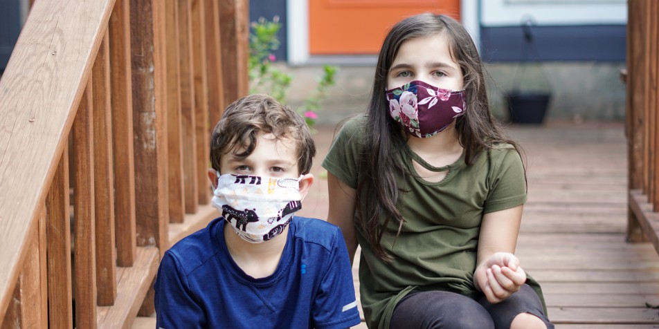 two children in covid-19 face masks