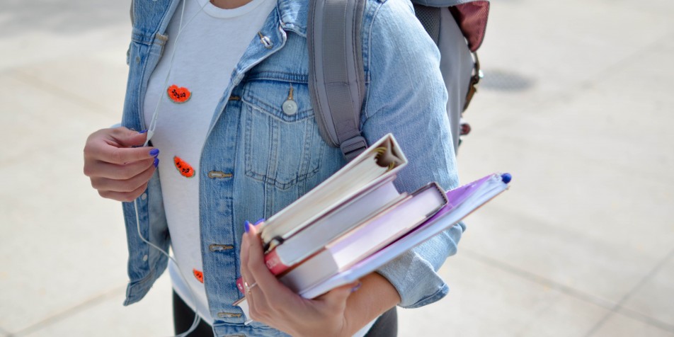 youth with school books, backpack, headphones 