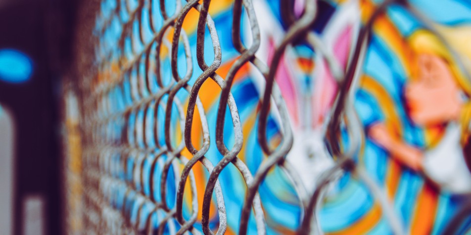 chain link fence in front of mural