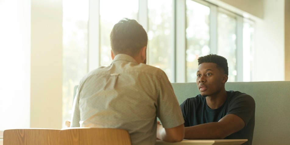 two people sitting at a table inside