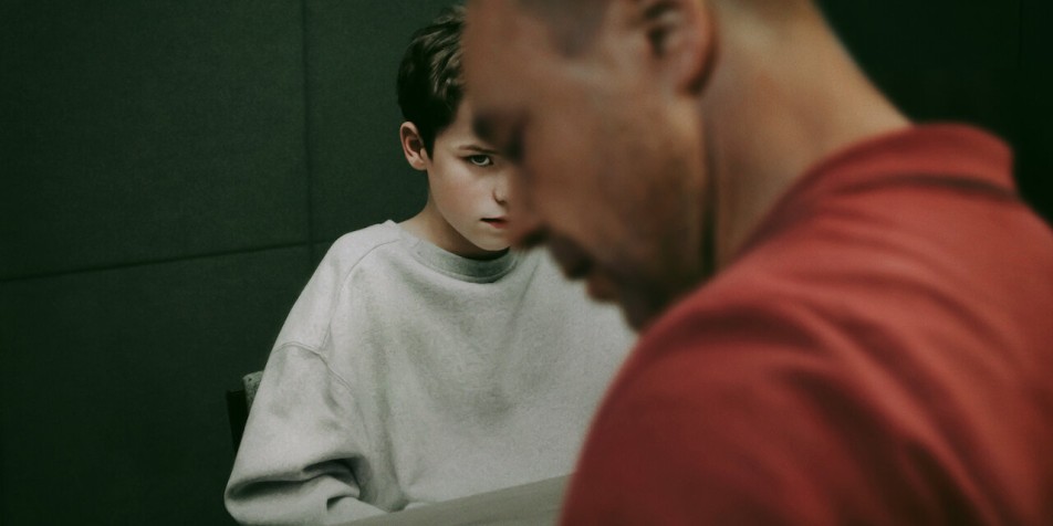 A young boy is in a carceral setting.