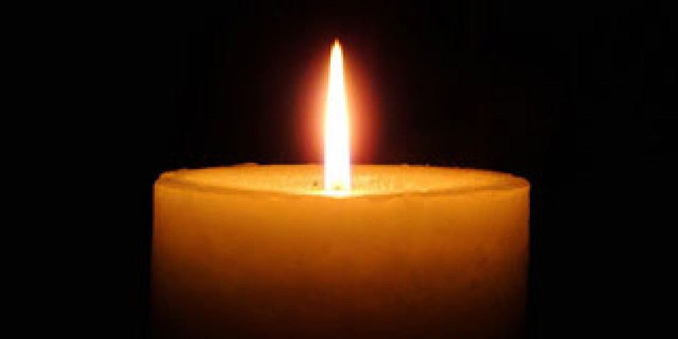 flame of a single orange candle with black background