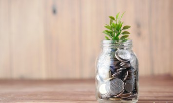 mason jar filled with coins and a small plant