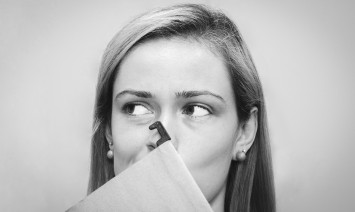 woman with a file folder in front of her face