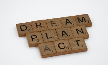 "dream, plan, and act" spelled with scrabble pieces